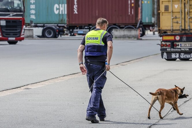 Ein Zollbeamter mit einem Drogenspürhund