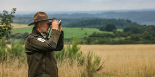 Eine Person mit Fernglas in der Natur.