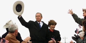 Präsident George W. Bush wedelt mit seinem Hut.