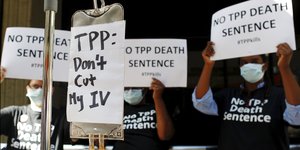 Demonstranten protestieren mit Schildern gegen das Freihandelsabkommen TPP.