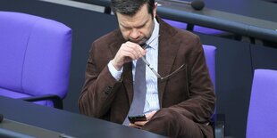 Justizminister Buschmann mit einem Smartphone.