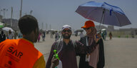 Zwei Pilger nahe Mekka unter einem Sonnenschirm