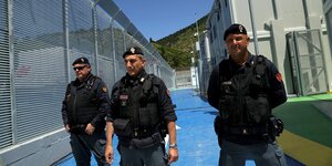 Drei Polizisten in einem Lager für Geflüchtete in Albanien
