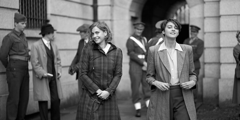 Thomasina (Emma Appleton) und Martha Hanbury (Stefanie Martini) stehen lächelnd in einem Hof.