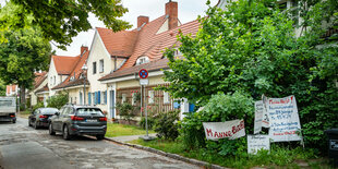 Ein Straße mit Wohnhäusern, an einem Transparente.