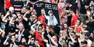 Ungarische Fans in schwarzen T-Shirts halten ein Plakat hoch mit der Forderung: Free Gigi!