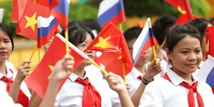 Vietnamesische Kinder mit vietnamesischen und russische Papierfähnchen