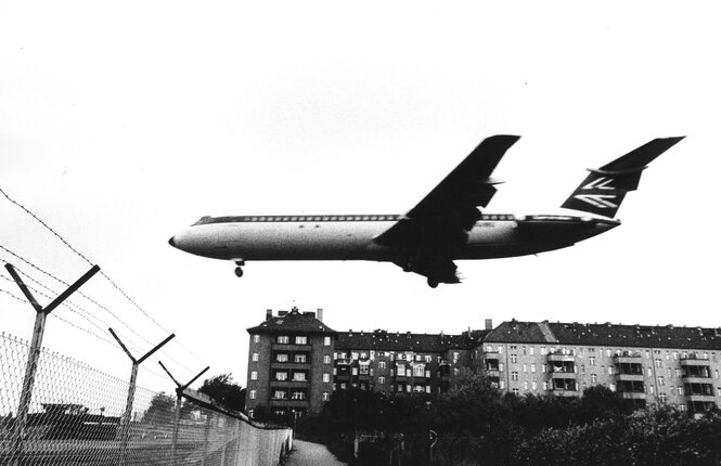 Ein Flugzeug fliegt knapp über Häuse hinweg