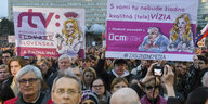 Menschen halten Plakate mit slowakischen Aufschriften