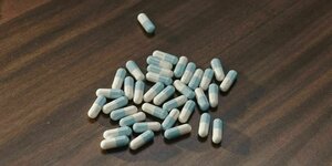 Placebopillen auf einem dunklen Holztisch