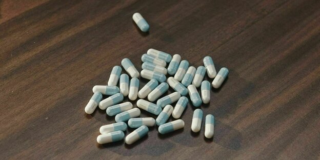 Placebopillen auf einem dunklen Holztisch