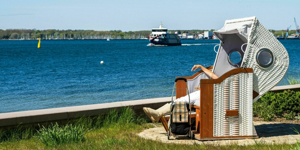 Eine Frau liegt in einem Strandkorb an einem sonnigen Tag