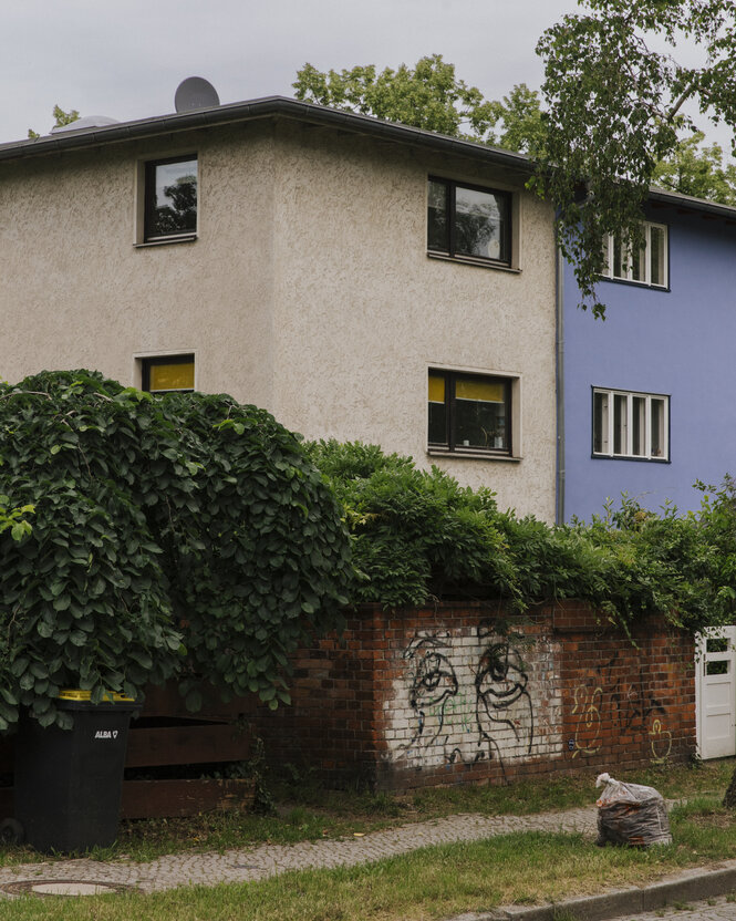 Ein weiß-blau gestrichenes Haus in der Papageiensiedlung