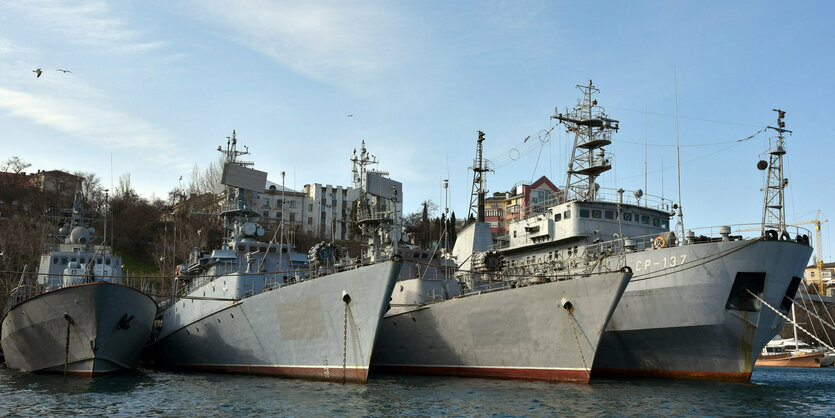 Kriegsschiffe in einem Hafen.