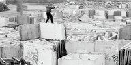 Ein Mann balanciert auf REsten der Berliner Mauer