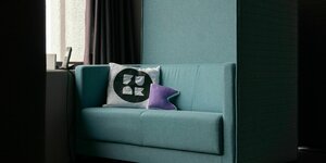 Auf einem Sofa liegt ein Kissen, welches mit dem funk-Logo bedruckt ist.