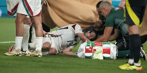 Ein Spieler der ungarischen Mannschaft liegt verletzt auf dem Spiel-Rasen und wird von Sanitätern behandelt