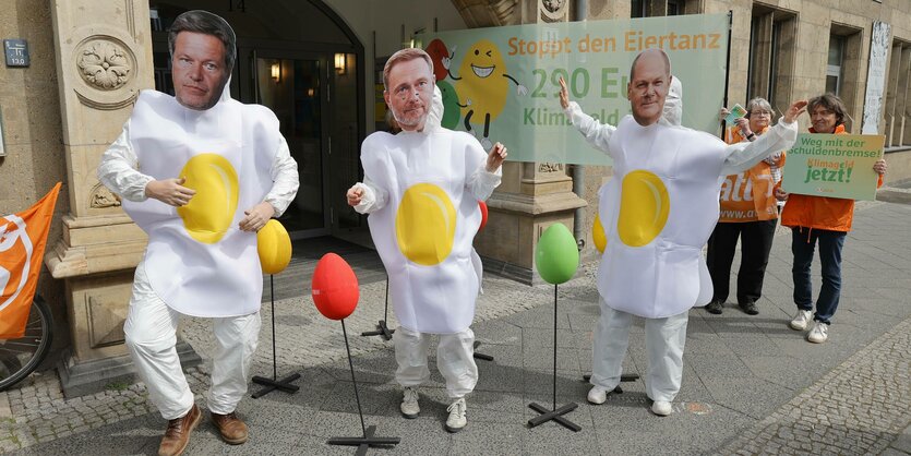 Protestaktion mit Masken von Lindner Habeck und Scholz.