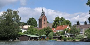 Eine Backsteinkirche vor einem See