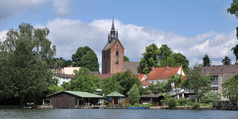 Eine Backsteinkirche vor einem See