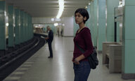 Eine Frau steht an einem Bahnsteig in der Berliner U-Bahn
