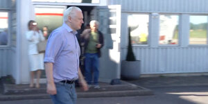 Julian Assange auf dem Weg zu einem Flugzeug an einem Londoner Flughafen.