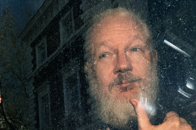 Julian Assange mit langem Vollbart sitzt in einem Auto