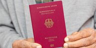 Hände halten einen deutschen Reisepass