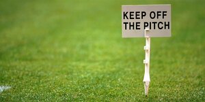 Ein Schild auf einem Fußballrasen, auf dem steht: Keep off the pitch