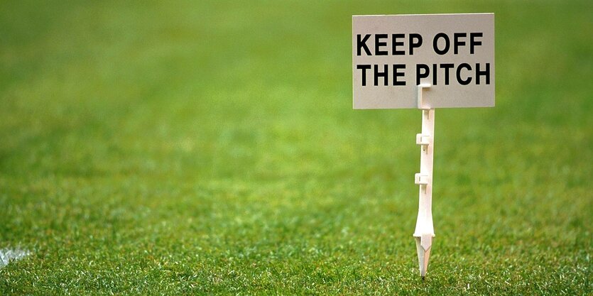 Ein Schild auf einem Fußballrasen, auf dem steht: Keep off the pitch