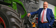 Joachim Rukwied posiert neben einem großen Traktor