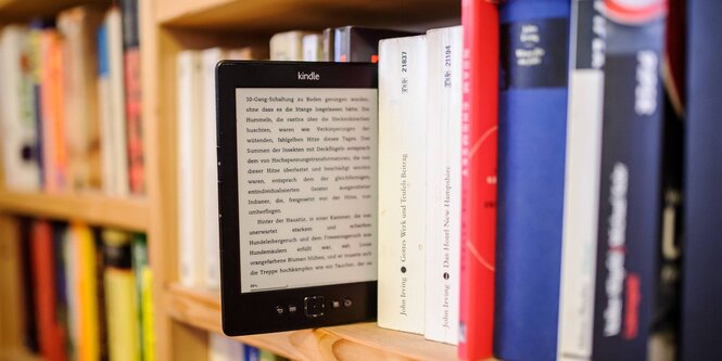 Kindle, herausgezogen aus einem Regal voller Bücher