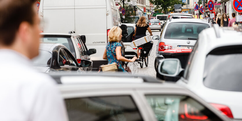 Autos und Radfaher:innen stehen dicht gedrängt auf einer Straße