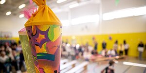 Bei der Einschulungsfeier der Pusteblume-Grundschule hängen Schultüten an der Wand