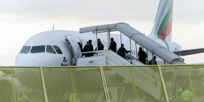 Mehrere Personen steigen in ein Flugzeug.