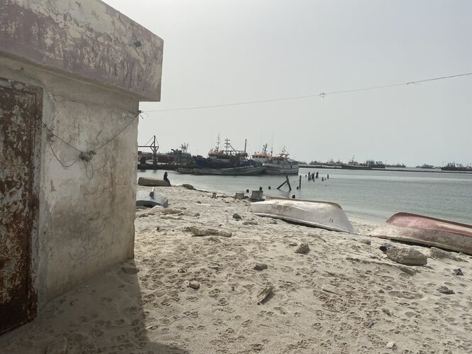 Ein Strandhafen. Im Sand liegen Boote auf dem Kopf