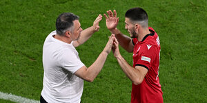 Georgiens Trainer klatscht mit einem Spieler bei dessen Auswechslung ab
