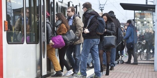 Pendler steigen in Köln-Sürth in eine Straßenbahn der Linie 16 ein