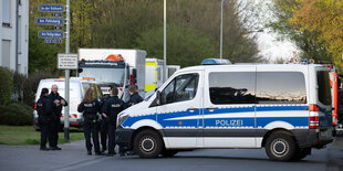 Polizeiwagen und Polizisten auf einer Strasse.