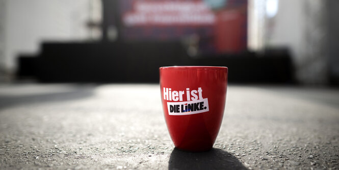 Eine rote Tasse mit der Aufschrift "Hier ist die Linke"