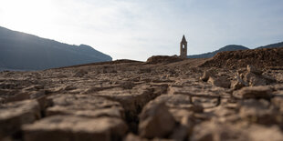 Getrocknete Landschaft mit einem Kirchenturm im Hintergrund