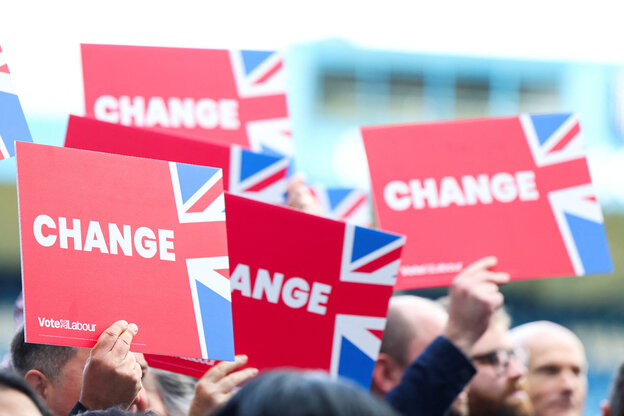 Anhänger der Labour-Partei halten Schilder hoch: weiße Schrift auf rotem Hintergrund mit angeschnittener UK Flagge und der Botschaft Change