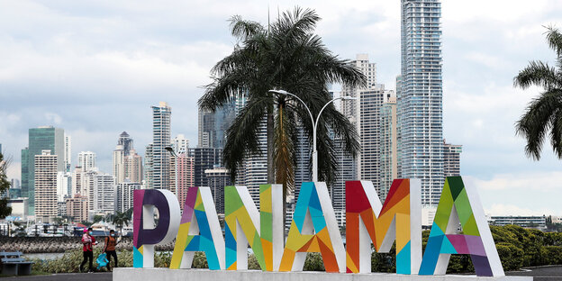 Eine Outdoor-Installation - bestehend aus einem bunten „Panama“-Schriftzug vor einer Hochhauskulisse