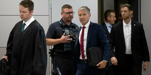 Björn Höcke (M), Vorsitzender der Thüringer AfD, kommt kurz vor der Urteilsverkündung nach seinem Anwalt Florian Gempe (l) in den Saal des Landgerichts.