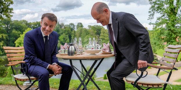 Emmanuel Macron und Olaf Scholz auf Gartenstühlen