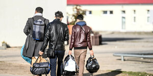 Drei Männer mit Reisetasche in der Zentralen Erstaufnahmeeinrichtung in Eisenhüttenstadt