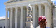 Vor dem Gebäude des Obersten Gerichtshofes in Washington steht ein Mann mit einer Pro-Trump-Mütze