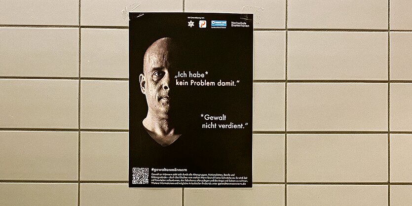 Ein Plakat der Kampagne hängt an einer gefließten Wand.