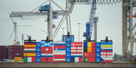 Container, die mit Nationalflaggen bemalt sind, sind im Hamburger Hafen aufeinander gestapelt