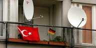 Eine türkische und eine deutsche Flagge hängen nebeneinander auf einem Balkon
